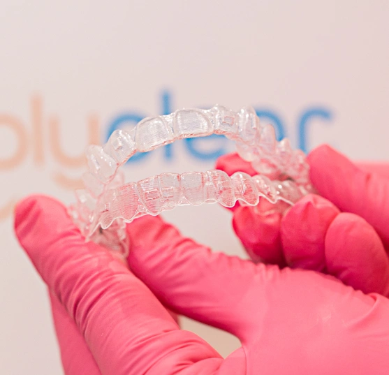 Dental professional holding a set of clear aligners