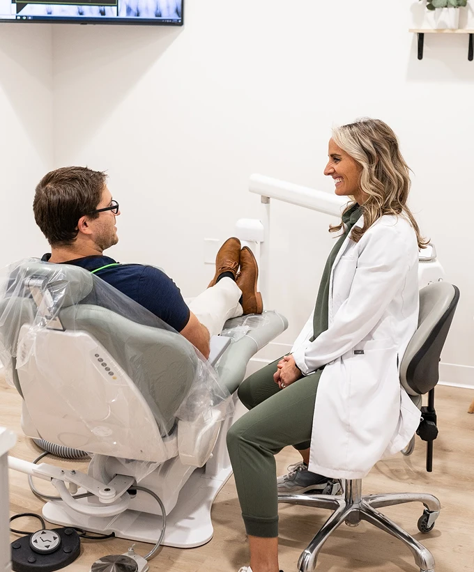 Dentist talking with a patient during treatment