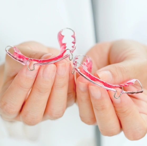 Hands holding a removable orthodontic retainer